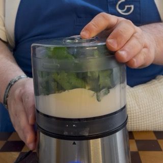 Chiusura del coperchio del frullatore e avvio delle lame a velocità medio-alta.