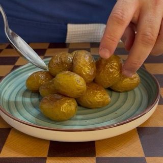 Disposizione delle patate novelle su un piatto da portata, sovrapponendole leggermente.