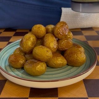 versamento a filo della crema allo yogurt e d'erbe sopra le patate arrosto croccanti fuori e morbide dentro.