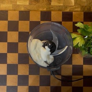 Inserimento di yogurt bianco naturale e maionese nel boccale di un cutter o frullatore.