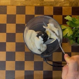 Aggiunta di erbe aromatiche fresche a scelta nel mixer per completare la salsa delle patate arrosto perfette.