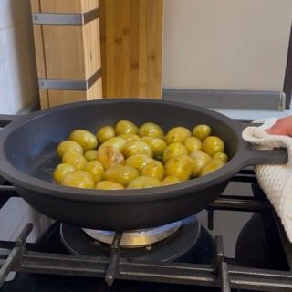 Rosolatura a fuoco vivo delle patate novelle muovendo la padella per dorarle uniformemente.