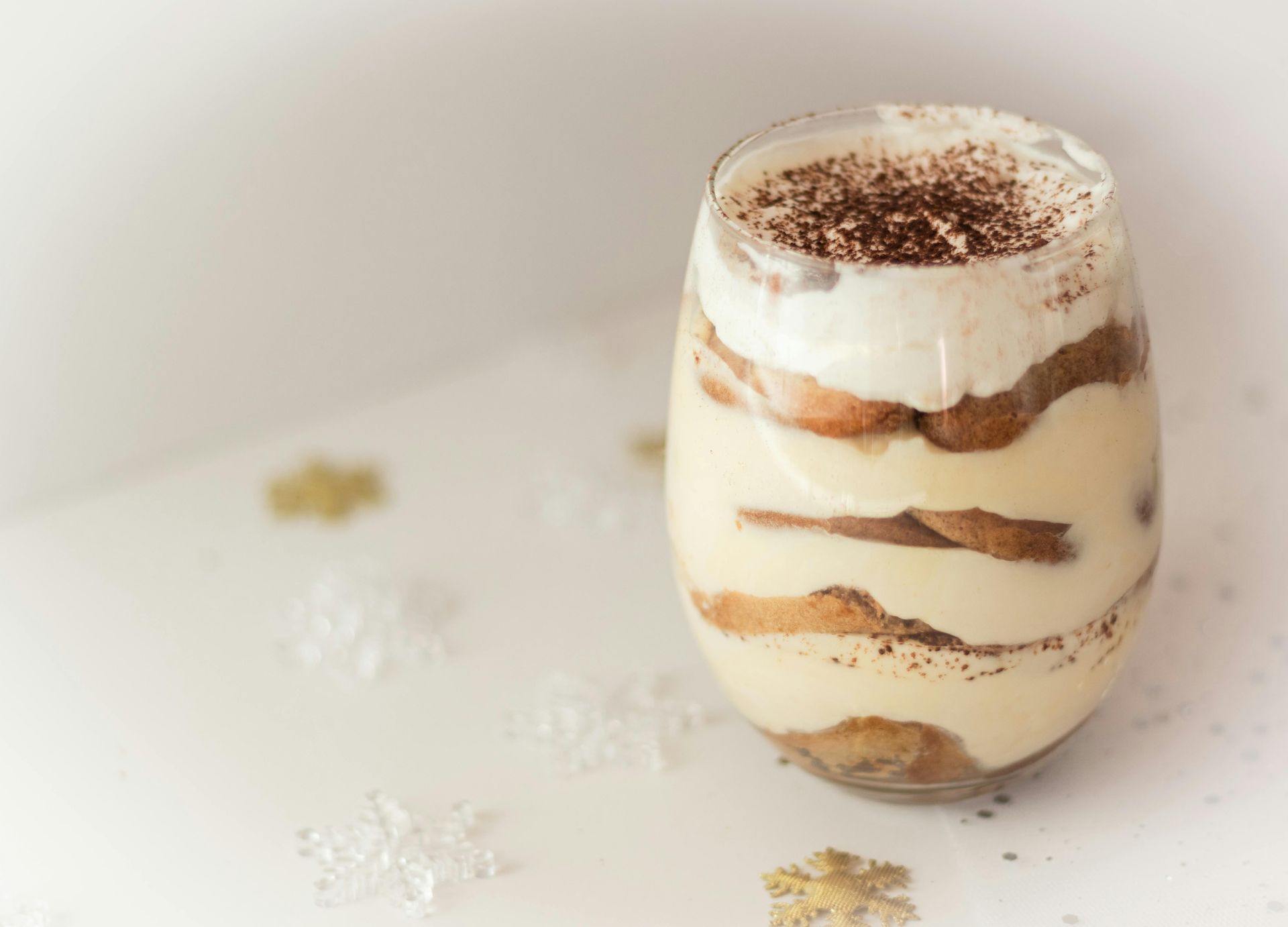 Tiramisù monoporzione servito in un bicchiere, che mostra gli strati di crema al mascarpone soffice e savoiardi al caffè.