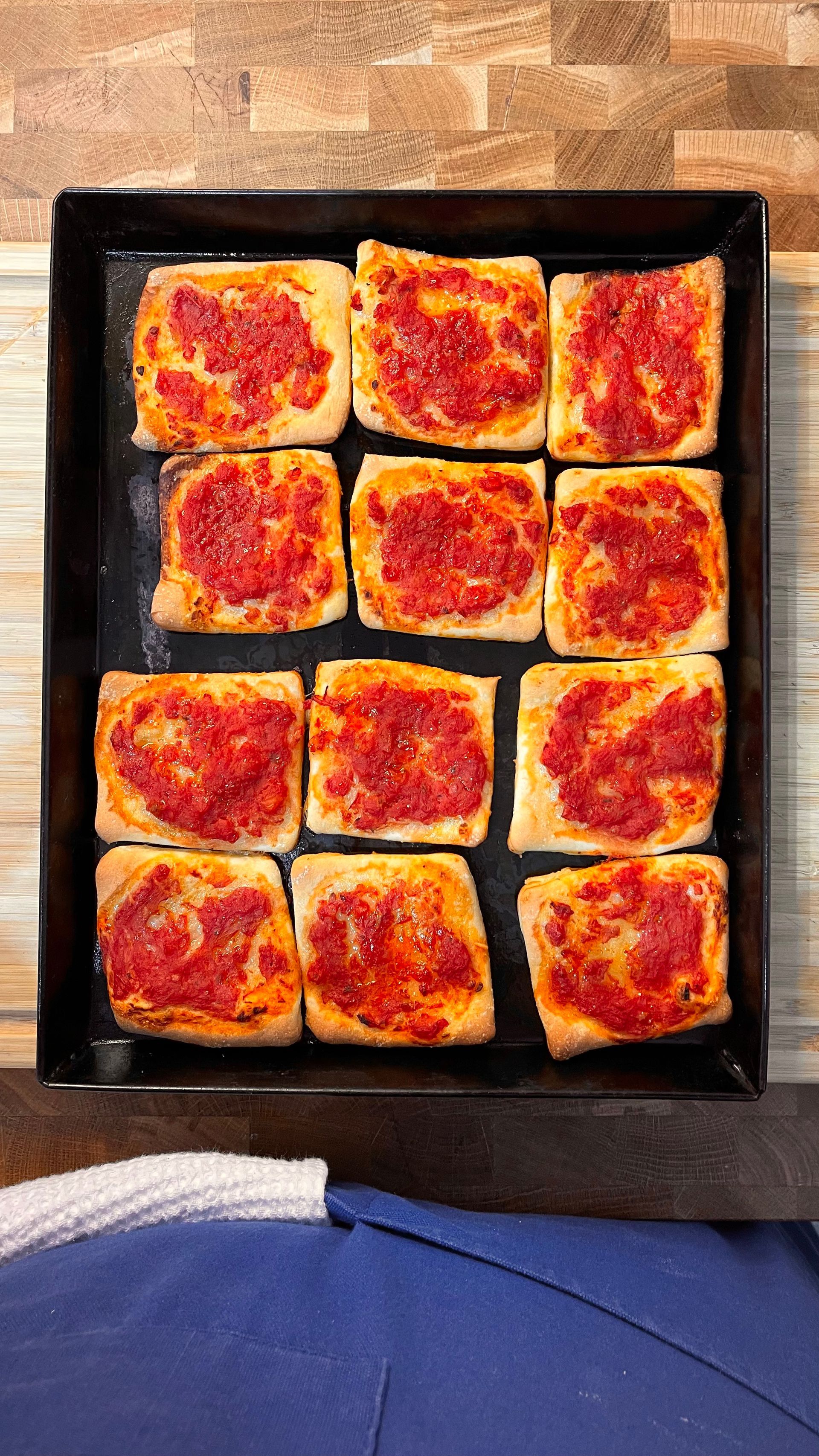 Una padella piena di fette di pizza con sopra il sugo di pomodoro.
