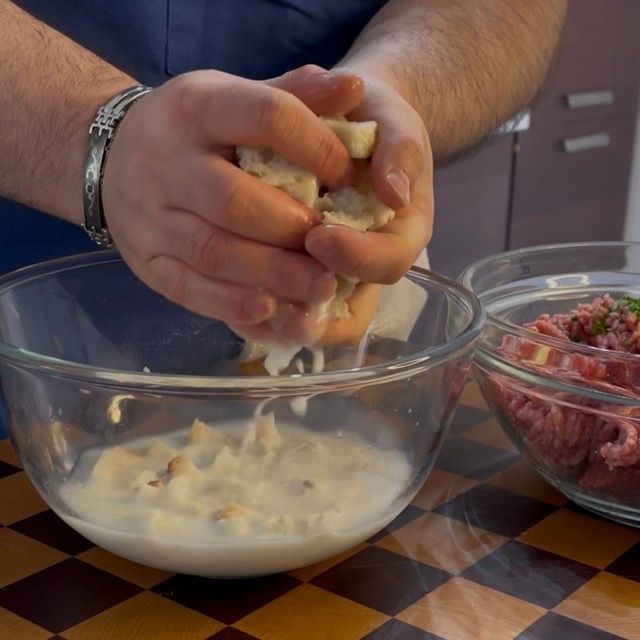Strizzatura manuale del pane ammollato nel latte per eliminare i liquidi in eccesso.