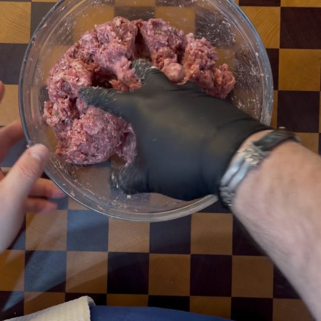 Lavorazione manuale degli ingredienti nella ciotola per amalgamare la carne.