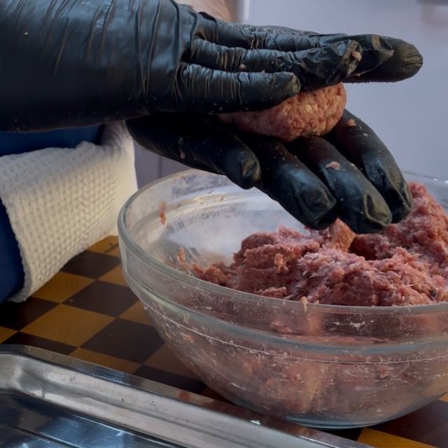 Serie di palline di carne tonde e regolari pronte per essere cucinate.