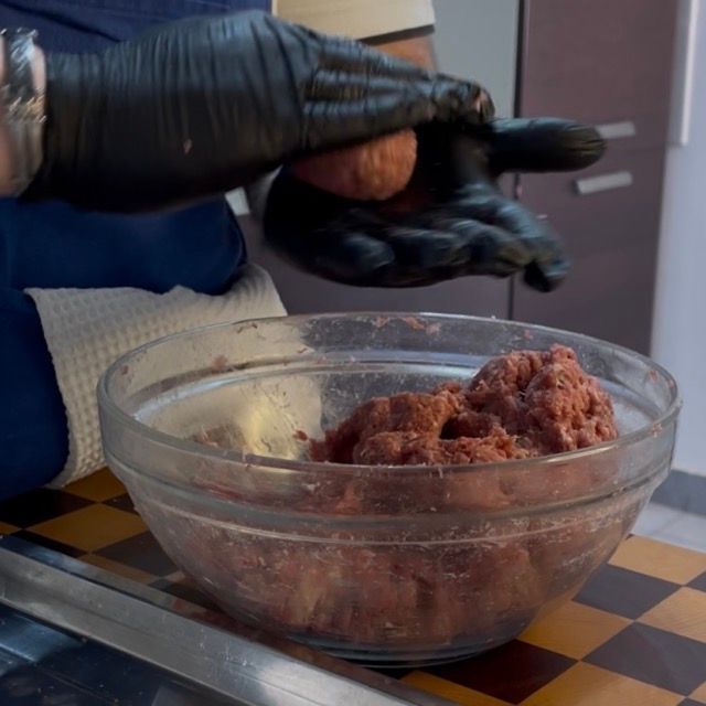 Formatura manuale delle polpette facendole ruotare tra i palmi delle mani.