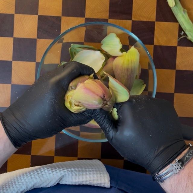 Pulizia della base del carciofo con un coltellino per eliminare le parti verdi scure.