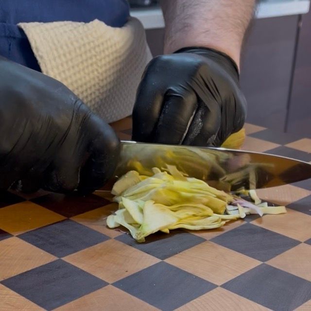 Affettatura sottile a spicchi dei carciofi per la cottura con le polpette di carne.