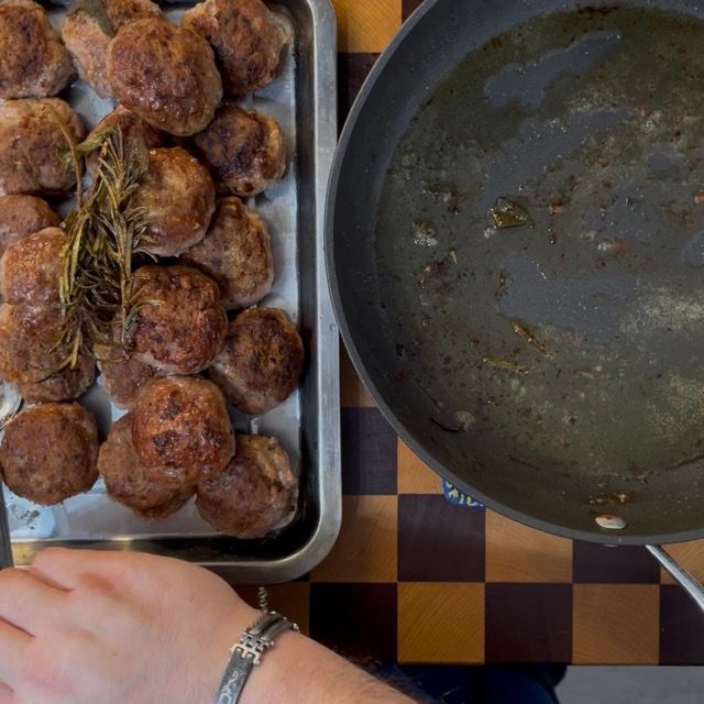 Trasferimento delle polpette dorate e sigillate su un vassoio pulito, messe da parte momentaneamente.