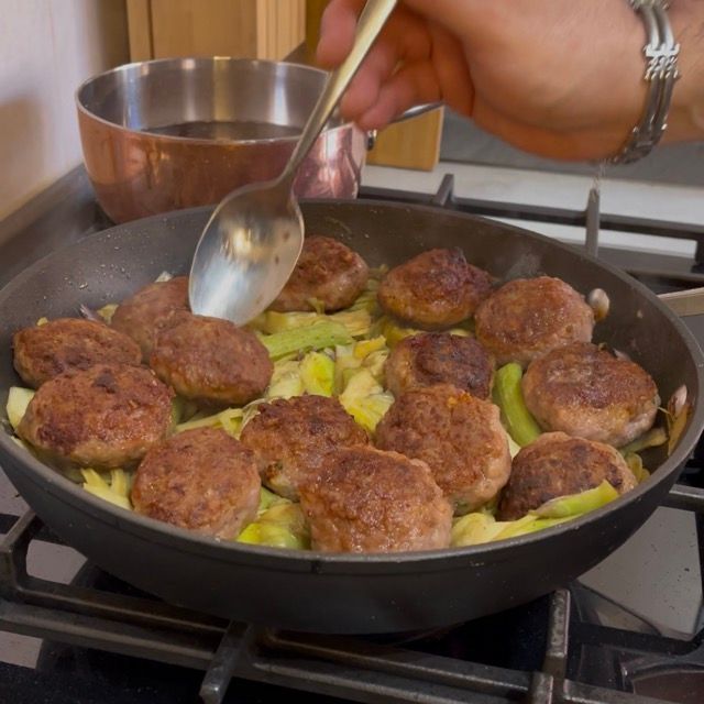 Ritorno delle polpette di carne messe da parte nella padella insieme ai carciofi.