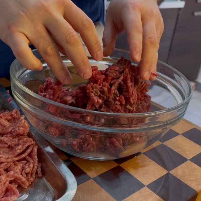 Unione di carne macinata di vitella e di maiale in una ciotola per le polpette di carne.