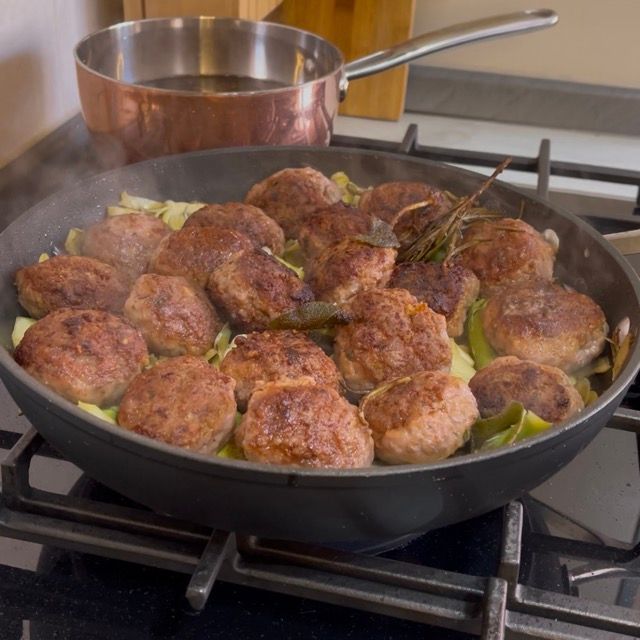 Versamento del vino bianco secco sopra le polpette e i carciofi dopo due minuti.