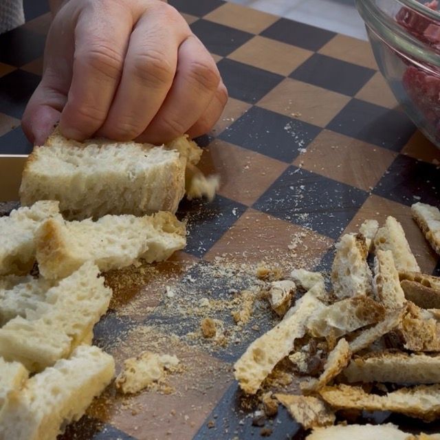 Pane a pezzetti trasferito in una ciotola capiente per la preparazione delle polpette.