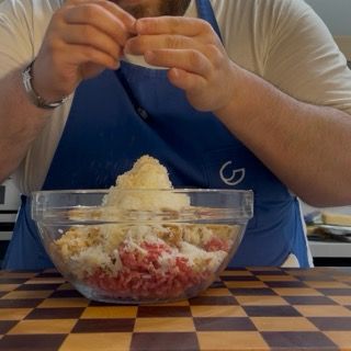 Condimento del mix di carne con una spolverata di sale fino e pepe nero per le nostre polpette ricette.