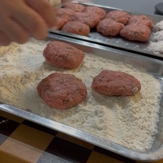 Passaggio rapido e uniforme di una polpetta all'interno di una ciotola con la farina.