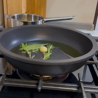 Inserimento nel fondo aromatico di uno spicchio d'aglio, rametti di rosmarino e foglie di salvia.