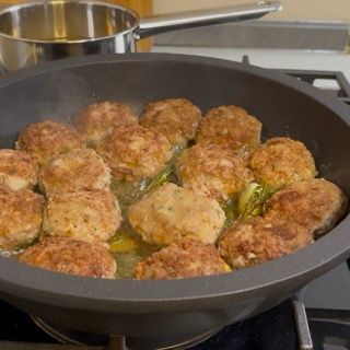 Trasferimento provvisorio delle polpette arrostite su un vassoio per mantenere le polpette sfiziose in padella succose.