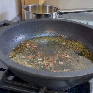 Riposizionamento della padella con i succhi della carne sul fuoco a fiamma media.