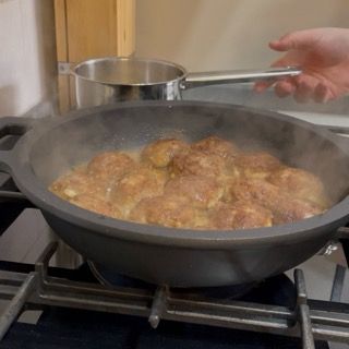 Aggiunta del brodo caldo nel tegame fino a coprire i due terzi dell'altezza delle polpette.