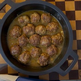Spegnimento della fiamma sotto la padella fumante delle polpette di carne morbide in padella.