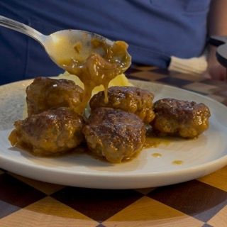 Presentazione finale delle polpette nappate con il loro sughetto ristretto, pronte da servire a tavola.