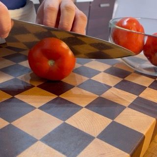 Selezione e lavaggio di pomodori rossi grandi e sodi, ideali per la ricetta dei pomodori con riso al forno.