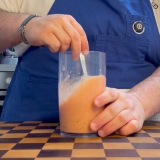 Aggiunta di aglio grattugiato fresco e un giro generoso di olio evo nel condimento dei pomodori al riso.
