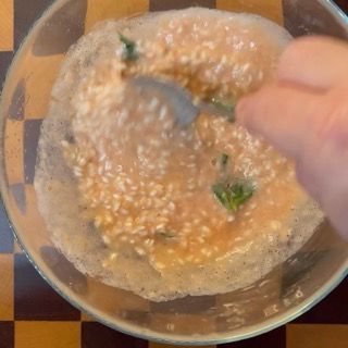 Mescolamento accurato del riso crudo nella polpa condita per avviare la marinatura e l'assorbimento.