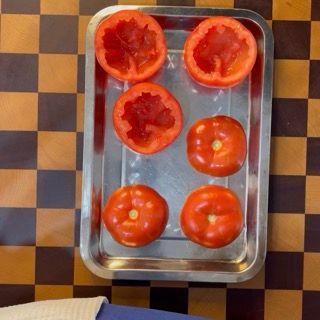 Salatura e oliatura dell'interno dei pomodori svuotati per insaporire l'involucro prima della farcitura.