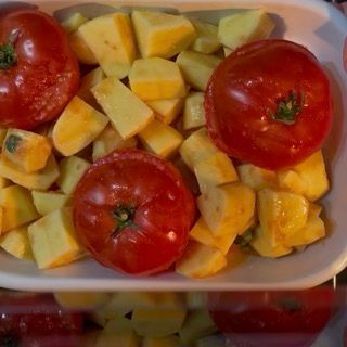 Ingresso della teglia nel forno statico preriscaldato a 200 gradi per la cottura di pomodori e patate.