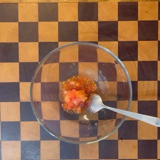 Contenitore riempito con tutta la polpa estratta dai pomodori rossi, base per il saporito condimento.