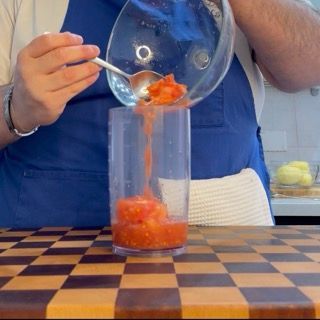 Frullatura della polpa di pomodoro estratta utilizzando un mixer ad immersione per ottenere una salsa liquida.