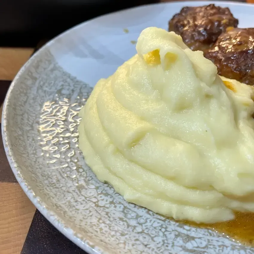 Piatto con un purè di patate fatto in casa soffice e cremoso, ricetta perfetta con latte e spolverata di noce moscata.