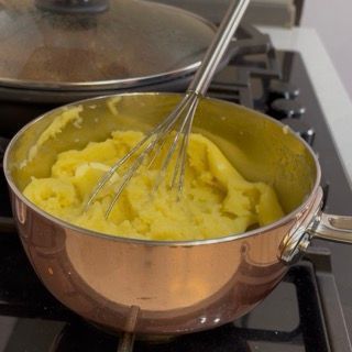 Riscaldamento del latte intero in un pentolino a parte per aggiungerlo caldo al purè.