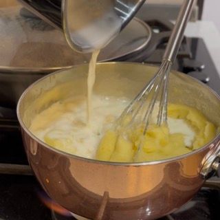 Mantecatura finale con la frusta sul fuoco per un purè di patate senza frullatore ben legato.