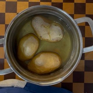 Pentola sul fuoco con acqua in ebollizione per cuocere le patate da purè di patate fatto in casa.