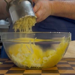 Pelatura delle patate bollite calde per preparare il purè di patate ricetta originale.