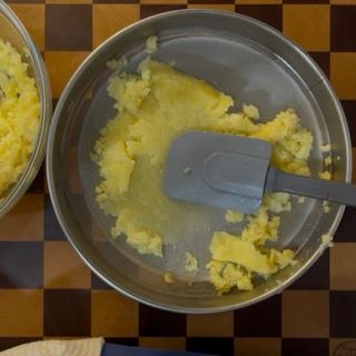 Passaggio delle patate nello schiacciapatate per ottenere un purè di patate senza minipimer
