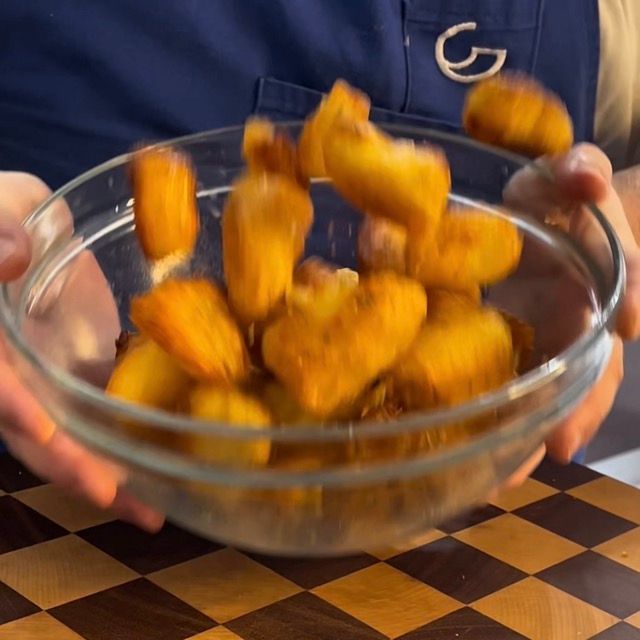 patata calde arrosto vengono fate saltare per ricoprirle con le erbe aromatiche 