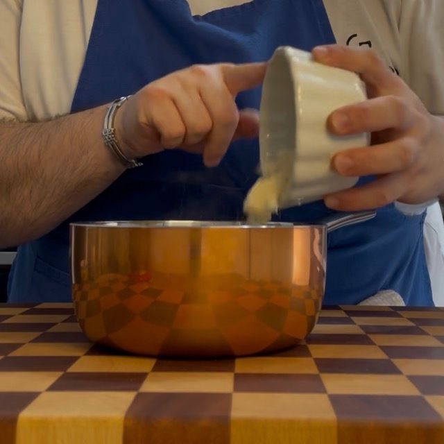 al risotto in una pentola viene aggiunto il formaggio grattugiato