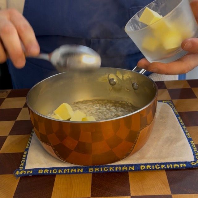 al risotto in una pentola viene aggiunto il burro