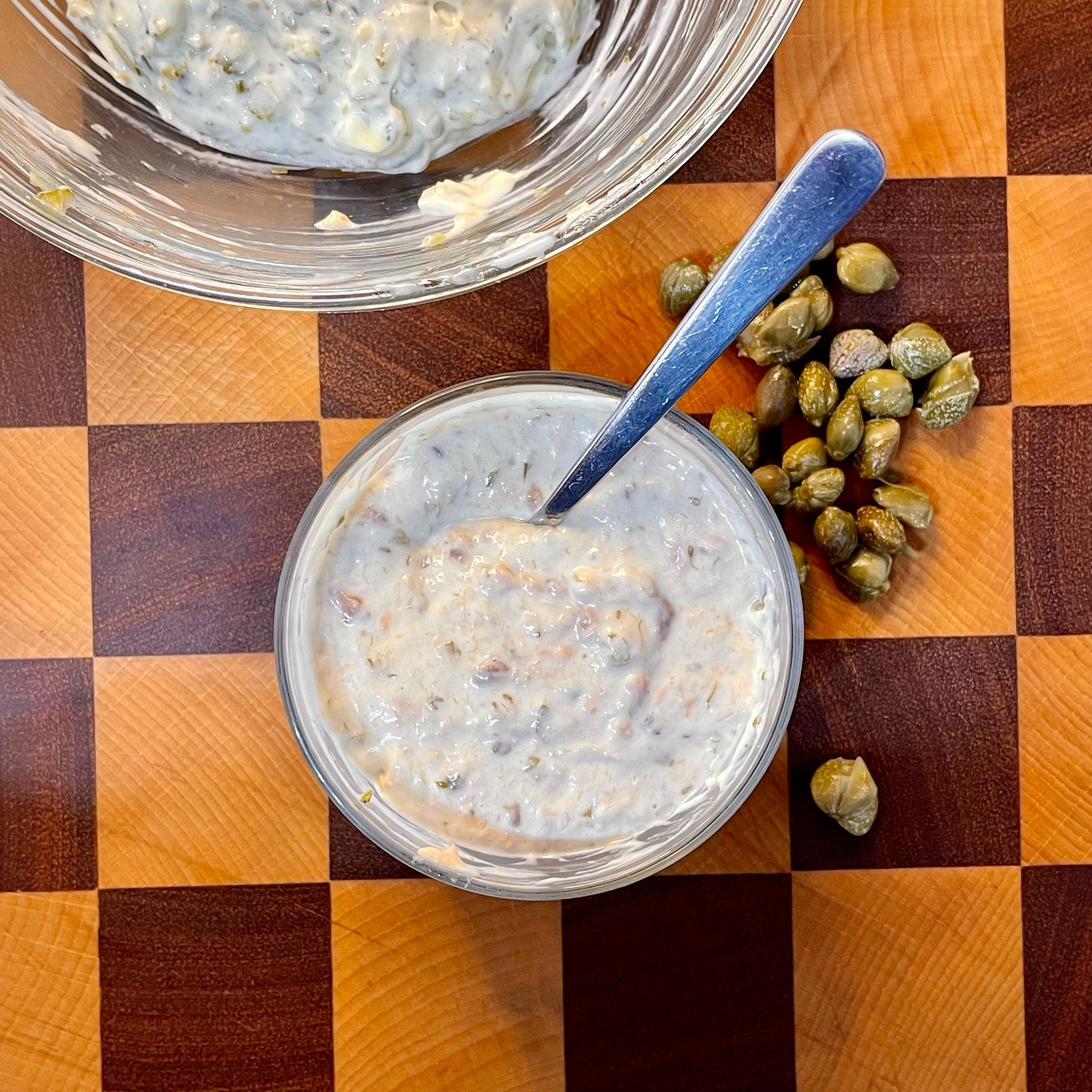 Salsa tonnata cremosa fatta in casa, servita in una ciotola bianca con capperi.