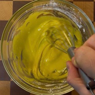 Latte e panna caldi versati sul composto di tuorli