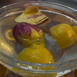 I carciofi immersi in una ciotola di acqua e limone