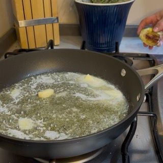 Spicchio d'aglio che sfrigola nel fondo di cottura