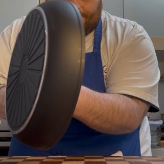Piatto da portata posizionato sopra la padella, pronto per il rovesciamento