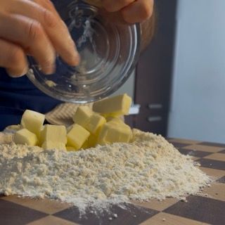 Farina, burro e acqua in una ciotola per la pasta brisée
