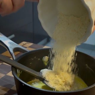 Parmigiano Reggiano grattugiato aggiunto alla crema calda fuori dal fuoco
